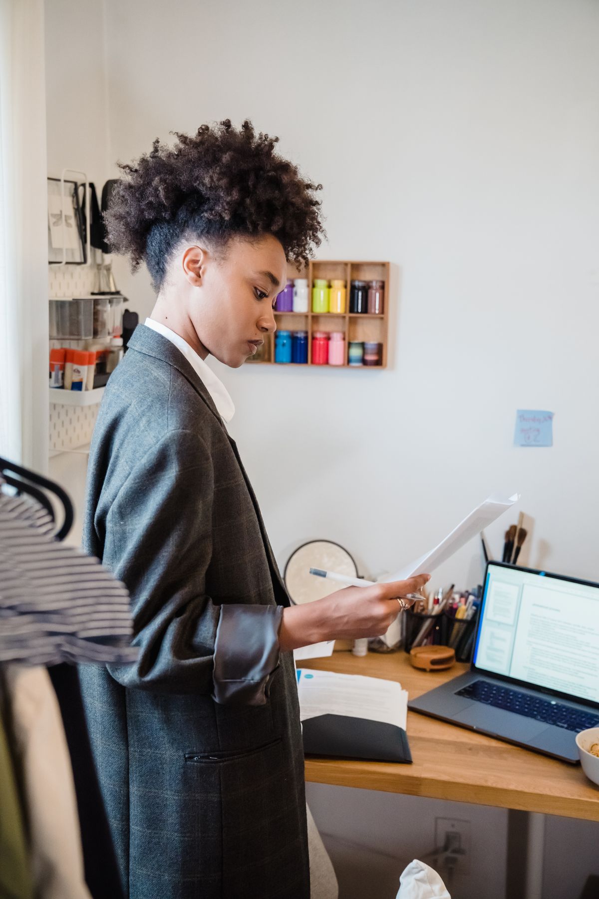 Une personne examine des documents près d’un ordinateur portable